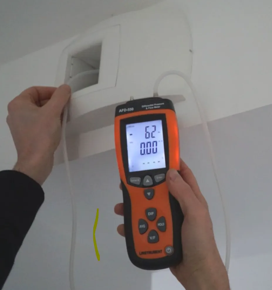 Technicien effectuant une mesure de débit sur une entrée d'air avec un cône