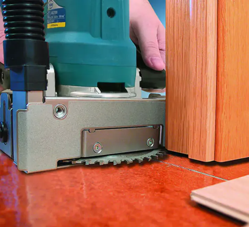 Technicien effectuant une découpe propre sur le bas d'une porte intérieure