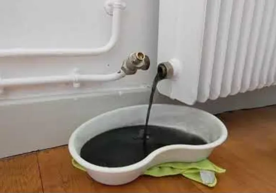 Radiateur démonté montrant l'accumulation de boues noires