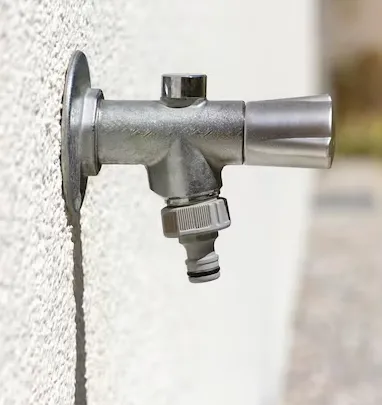 Coupe technique d'un robinet antigel installé à travers un mur porteur