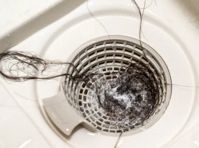 Siphon de douche obstrué par des cheveux et du savon